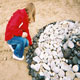 Girl with stones arranged in a circle on beach